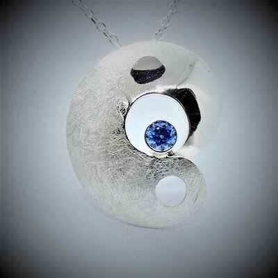Pendentif en argent massif bombé et brossé, décoré d'une zirkonia bleu clair de 4mm